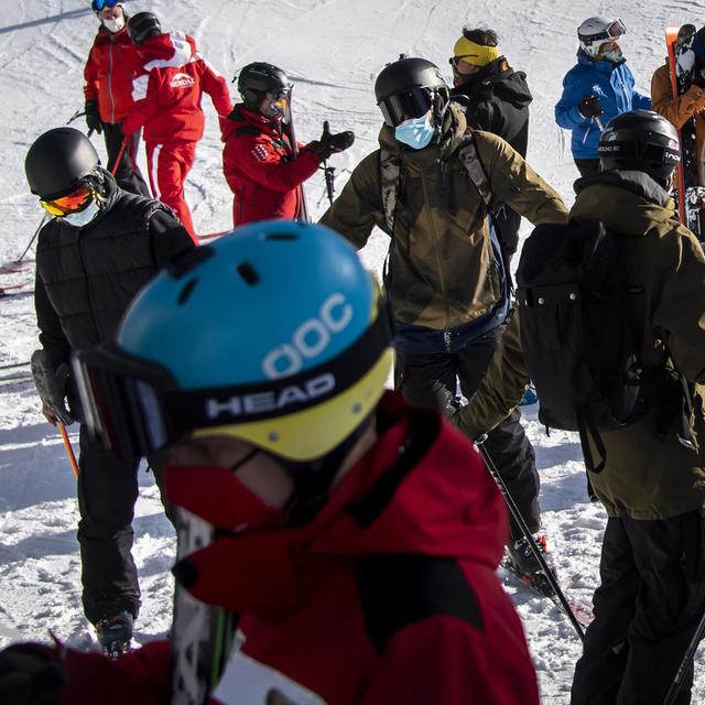 Des skieurs à Verbier portant un masque de protection. [Keystone - Jean-Christophe Bott]