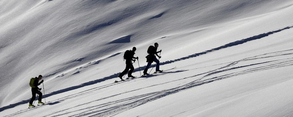 Des skieurs de randonnée profitent de la neige sur le domaine de Courchevel. [Keystone/EPA - Sébastien Nogier]