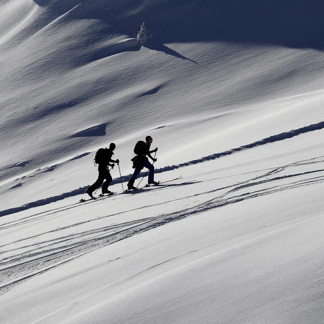 Des skieurs de randonnée profitent de la neige sur le domaine de Courchevel. [Keystone/EPA - Sébastien Nogier]