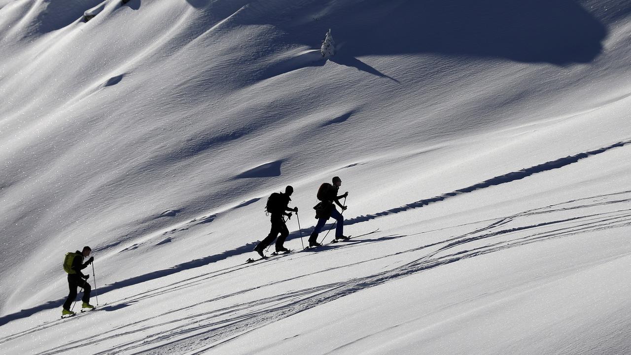 Des skieurs de randonnée profitent de la neige sur le domaine de Courchevel. [Keystone/EPA - Sébastien Nogier]