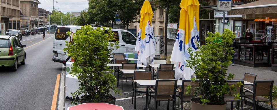 Une vue sur la terrasse d'un bar qui a pris place sur des places de parking pour voitures, à Lausanne. [keystone - Jean-Christophe Bott]