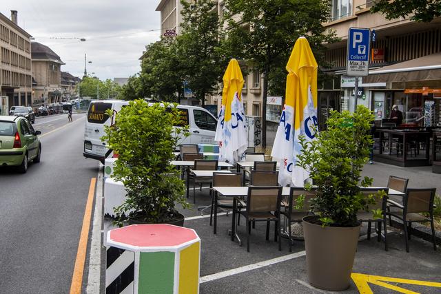 Une vue sur la terrasse d'un bar qui a pris place sur des places de parking pour voitures, à Lausanne. [keystone - Jean-Christophe Bott]