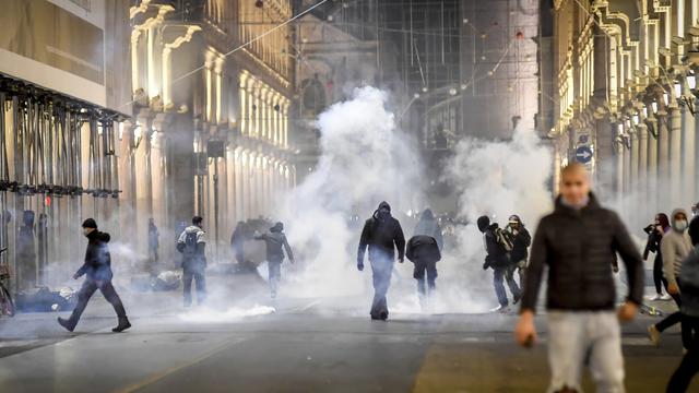 Affrontements entre policiers et manifestants anti-couvre-feu dans les rues de Turin. [Keystone/La Presse via AP - Claudio Furlan]