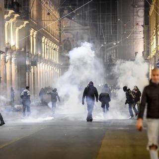 Affrontements entre policiers et manifestants anti-couvre-feu dans les rues de Turin. [Keystone/La Presse via AP - Claudio Furlan]