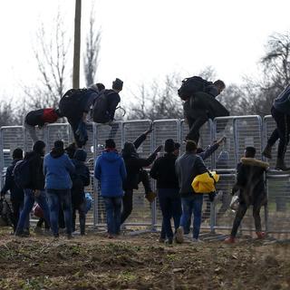 Des migrants escaladent une clôture installée par les autorités turques près de la frontière grecque à Pazarkule,le mercredi 4 mars 2020. [EP Photo/Keystone - Emrah Gurel]