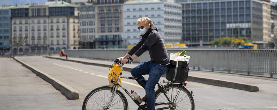 Une personne circule à vélo en ville de Genève. [Keystone - Salvatore Di Nolfi]