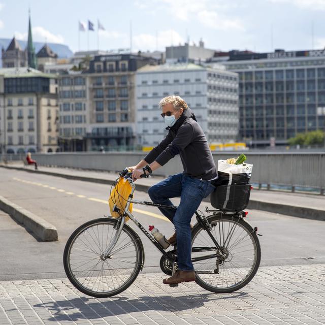 Une personne circule à vélo en ville de Genève. [Keystone - Salvatore Di Nolfi]