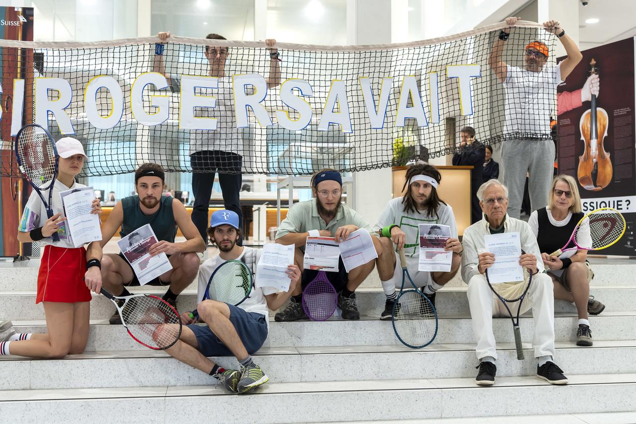 Des manifestants du collectif "Lausanne action climat" posent après avoir joué au tennis dans les locaux d'une succursale de Credit Suisse, le 22 novembre 2018 à Lausanne. [Keystone - Martial Trezzini]