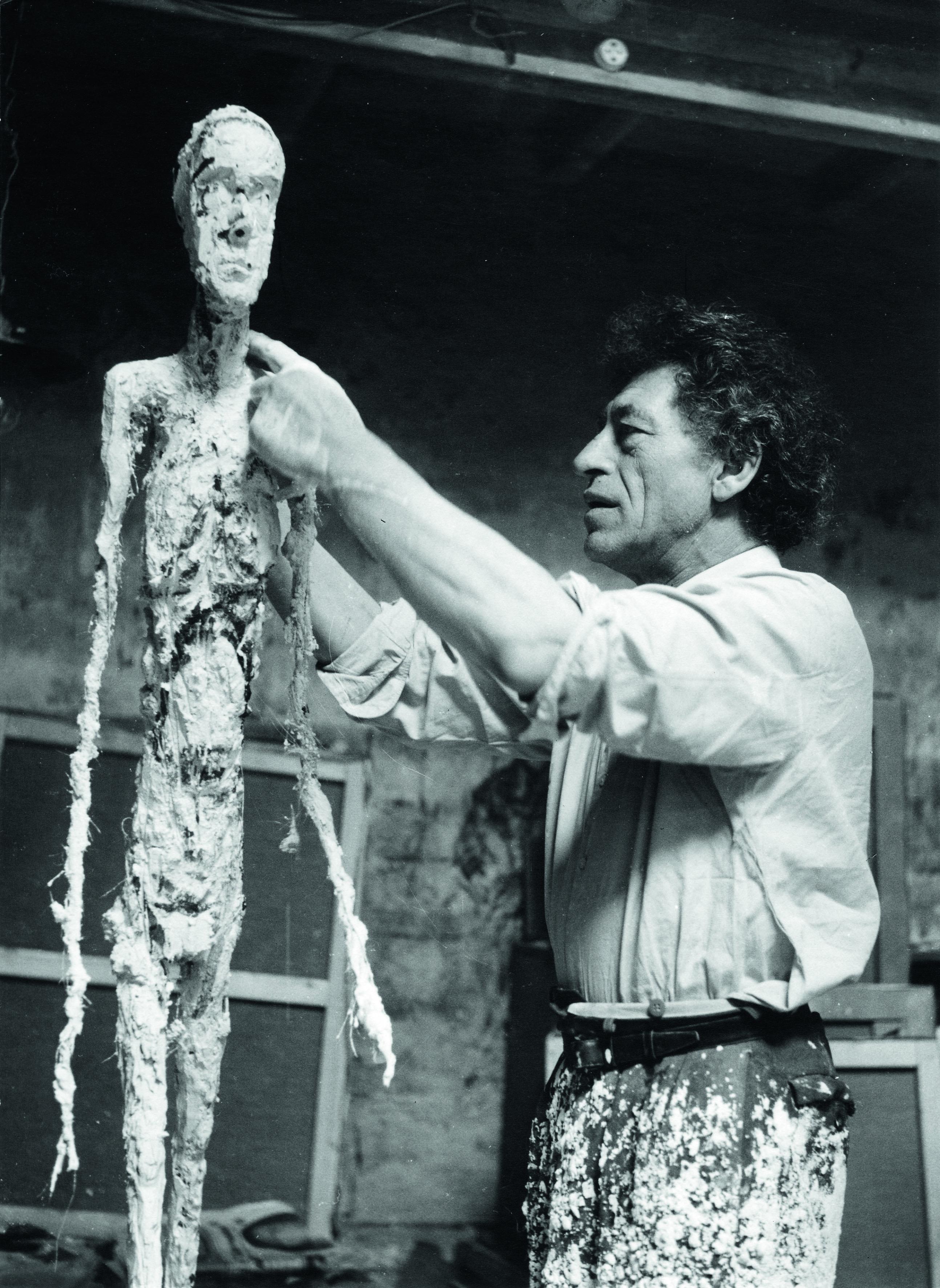 Alberto Giacometti travaillant au plâtre de "L'Homme qui marche" en 1959. [Fondation Giacometti  © Succession Alberto Giacometti - Ernst Scheidegger]