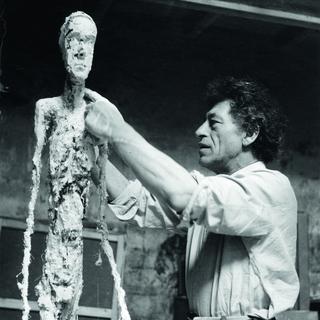 Alberto Giacometti travaillant au plâtre de "L'Homme qui marche" en 1959. [Fondation Giacometti  © Succession Alberto Giacometti - Ernst Scheidegger]