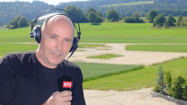 Ouls, responsable accueil et logistique des artistes au Chant du Gros devant le terrain vide du festival, au Noirmont. [Bastien von Wyss]