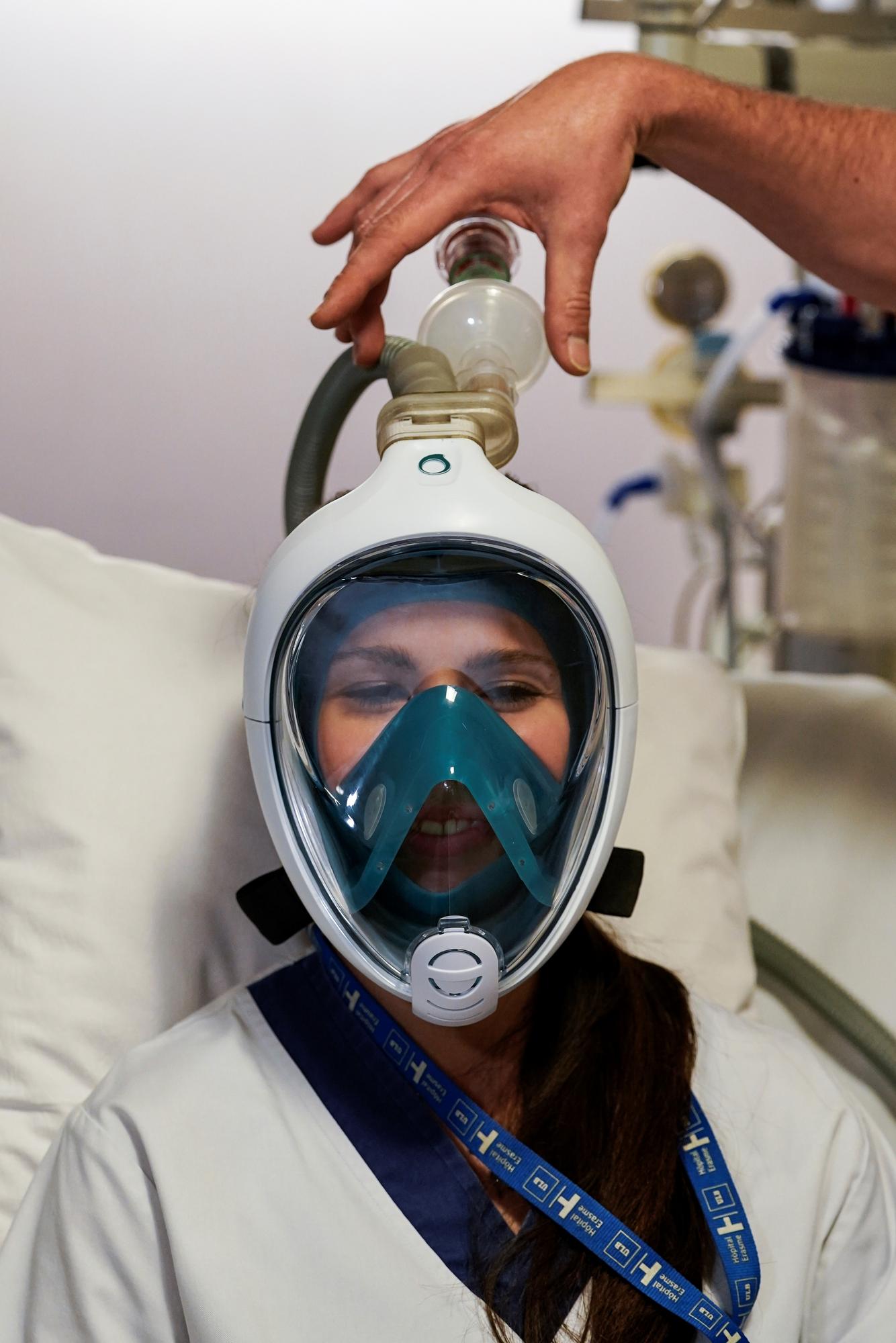Une assistante médicale teste le masque de snorkeling transformé en respirateur grâce à une valve imprimée en 3D. [afp - Kenzo Tribouillard]