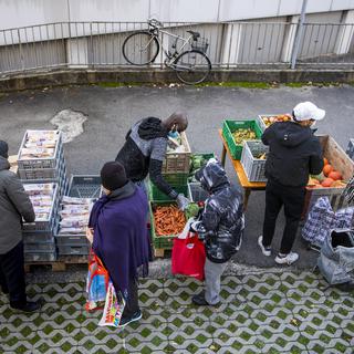 Des bénévoles de l'association Solid-ère distribuent des sacs alimentaires à Lausanne. [Keystone - Jean-Christophe Bott]