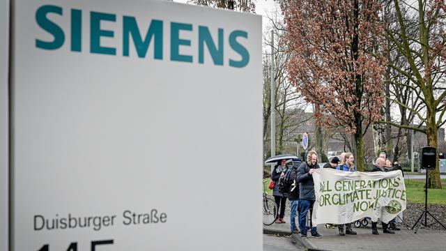 Des manifestants protestent devant l'administration de Siemens contre la participation du groupe allemand dans une mine de charbon australien. [EPA/Keystone - Sascha Steinbach]