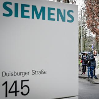Des manifestants protestent devant l'administration de Siemens contre la participation du groupe allemand dans une mine de charbon australien. [EPA/Keystone - Sascha Steinbach]
