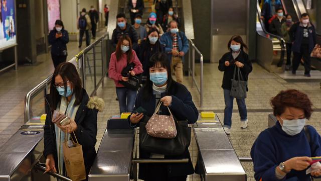 Pendulaires portant des masques dans une station de métro à Hong Kong suite à l'émergence du coronavirus. [EPA / Keystone - MIGUEL CANDELA]