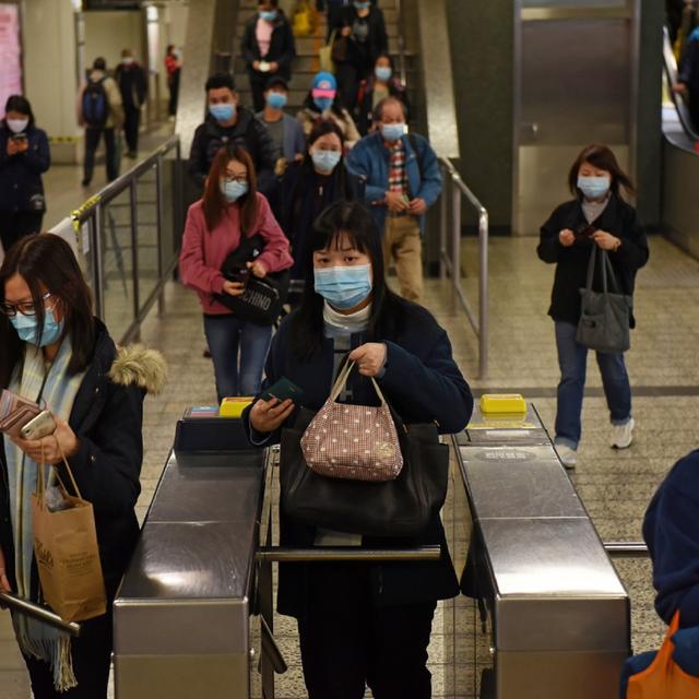 Pendulaires portant des masques dans une station de métro à Hong Kong suite à l'émergence du coronavirus. [EPA / Keystone - MIGUEL CANDELA]