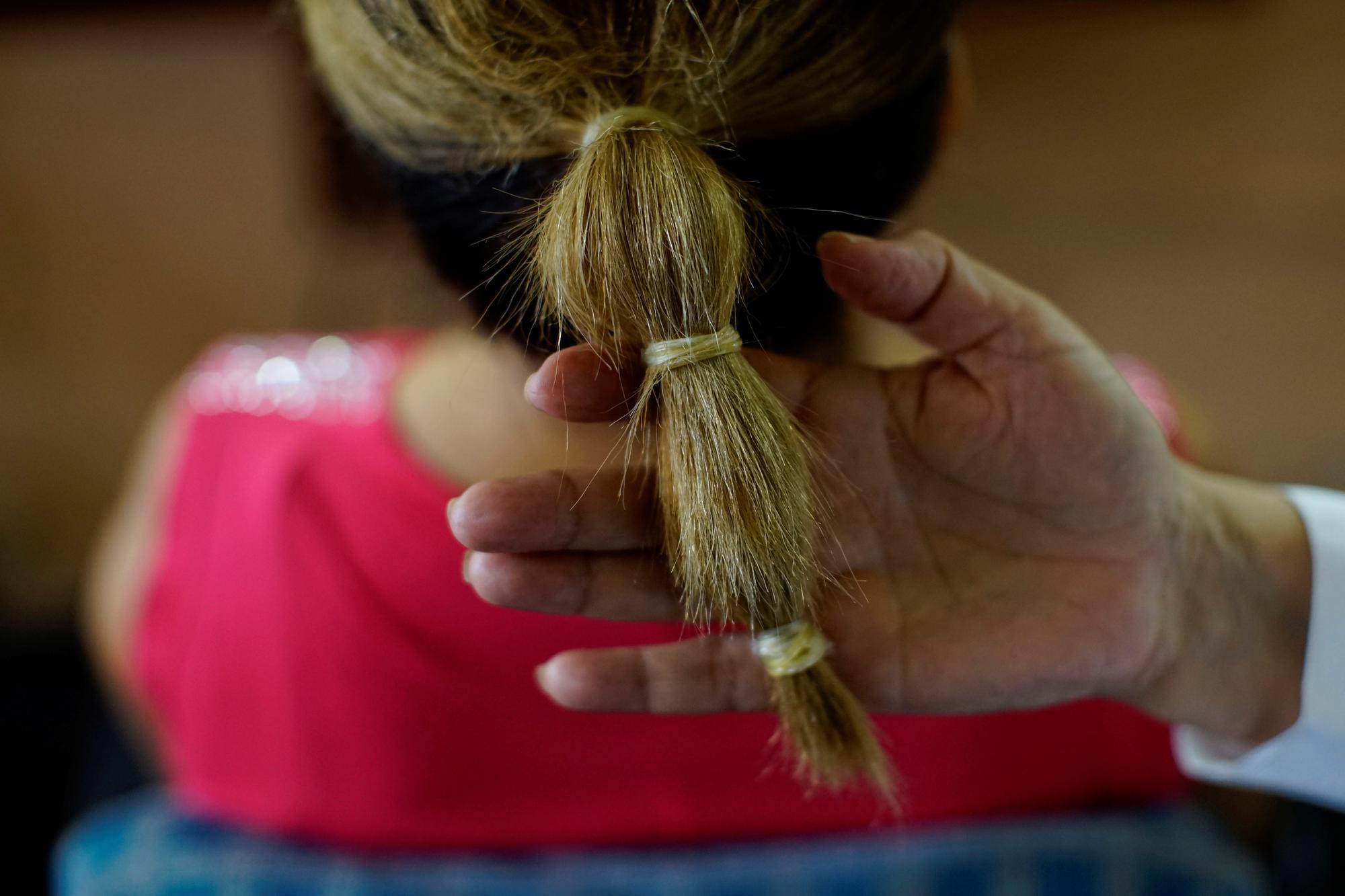 Une coiffeuse utilise les préservatifs comme élastique à cheveux à La Havane. [Reuters - Alexandre Meneghini]