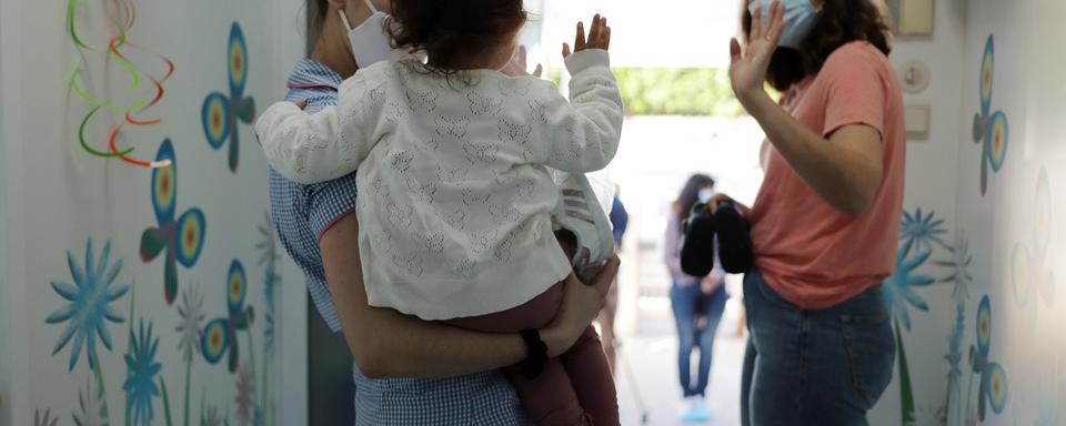 Une pétition fribourgeoise demande aux autorités d'abandonner l'obligation de porter le masque pour le personnel des crèches (image d'illustration). [Keystone/EPA - Estela Silva]