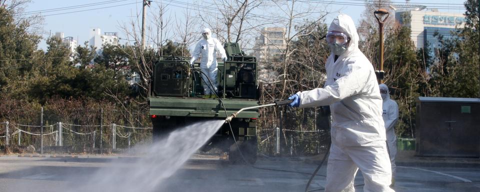 Un soldat désinfecte une rue en Corée du Sud. [Keystone - EPA/Kim Chul-Soo]