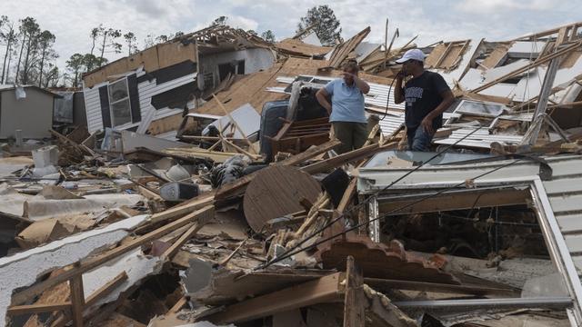 Deux personnes au milieu des décombres de leur maison détruite par le passage de l'ouragan Lauran à Lake Charles, en Louisiane, le 27 août 2020. [AFP - Andrew Caballero-Reynolds]