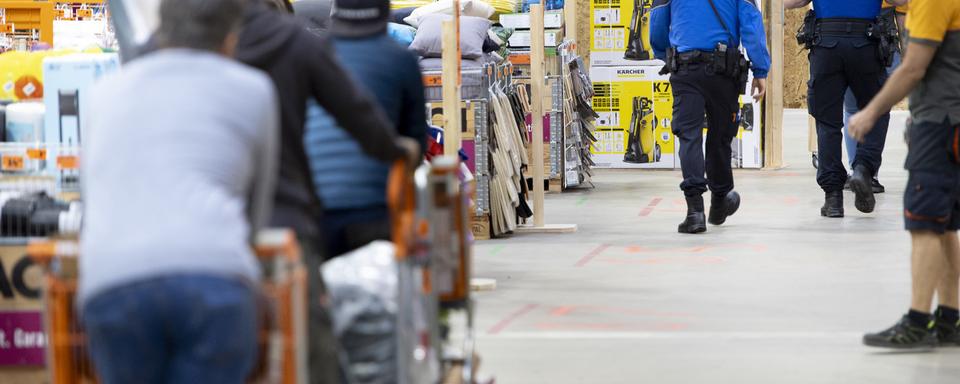 Des policiers patrouillent dans un magasin de bricolage. [Keystone - Laurent Gillieron]