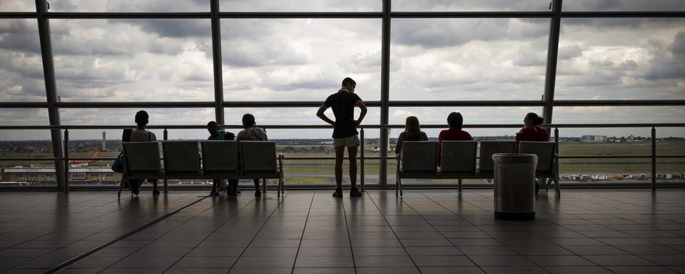 Lundi 21 décembre: des passager à l'aéroport de Johannesburg, en Afrique du Sud, pays désormais privé de connexions aériennes avec de nombreux autres pays. [Keystone - Kim Ludbrook]