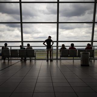 Lundi 21 décembre: des passager à l'aéroport de Johannesburg, en Afrique du Sud, pays désormais privé de connexions aériennes avec de nombreux autres pays. [Keystone - Kim Ludbrook]