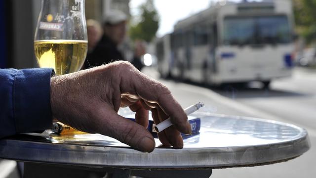 Un fumeur de cigarette relégué sur une terrasse d'un café au centre de Lausanne. [Keystone - Dominic Favre]