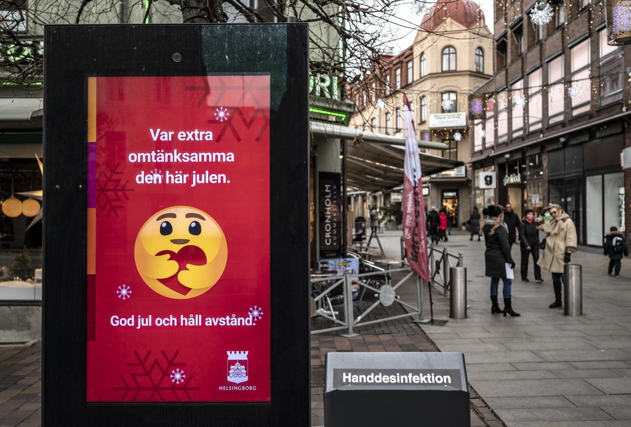 Une affiche souhaitant un joyeux Noël demande de maintenir les distances physiques, dans une rue de Helsingborg. Suède, le 7 décembre 2020. [Keystone/epa - Johan Nilsson]