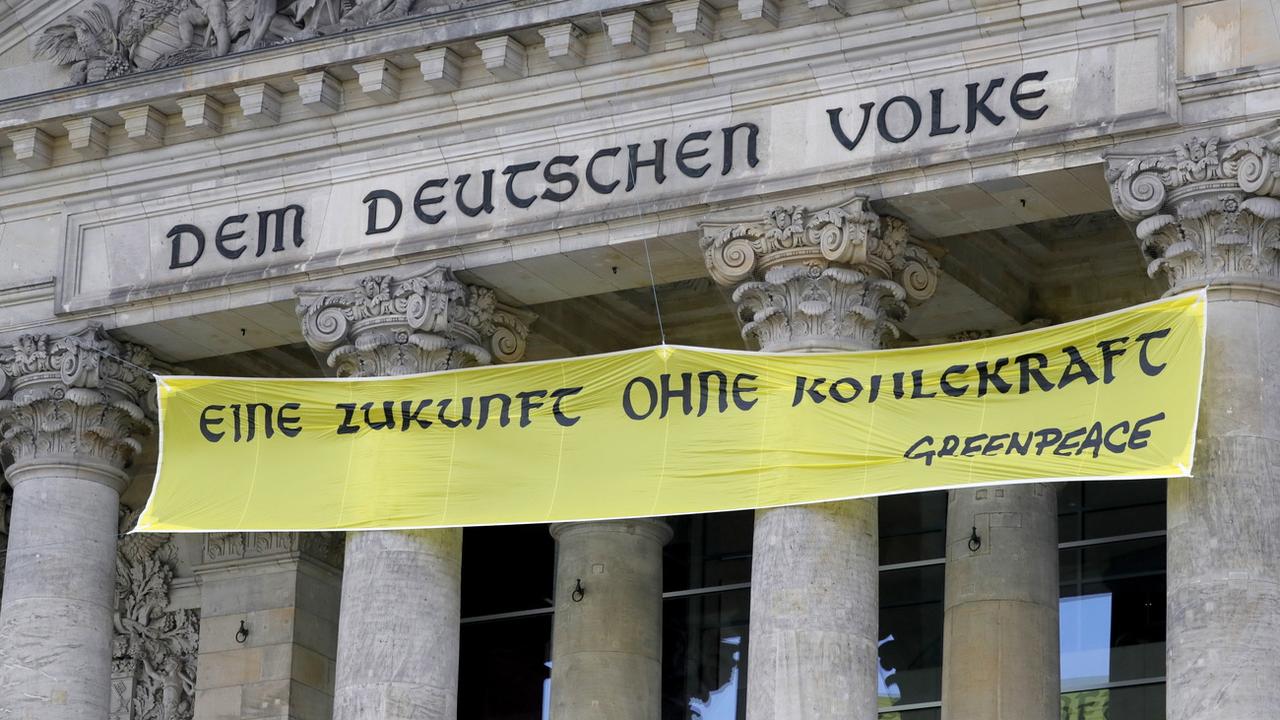 Sur la façade du Parlement allemand, une banderole de Greenpeace, qui veut sortir du charbon plus rapidement. [EPA - RONALD WITTEK]
