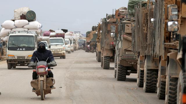 Sur le chemin de l'exil, les civils croisent les colonnes de véhicules militaires turcs en route vers le sud. [Reuters - Khalil Ashawi]