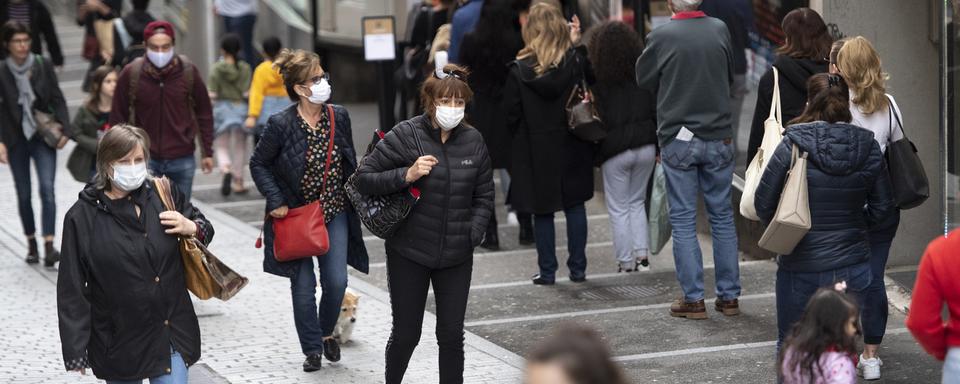 Des personnes masquées dans une rue à Lausanne. [Keystone - Laurent Gillieron]