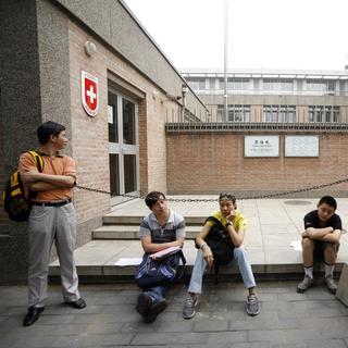 Des personne attendent devant l'ambassade suisse à Pékin. [Keystone - Alessandro Della Bella]
