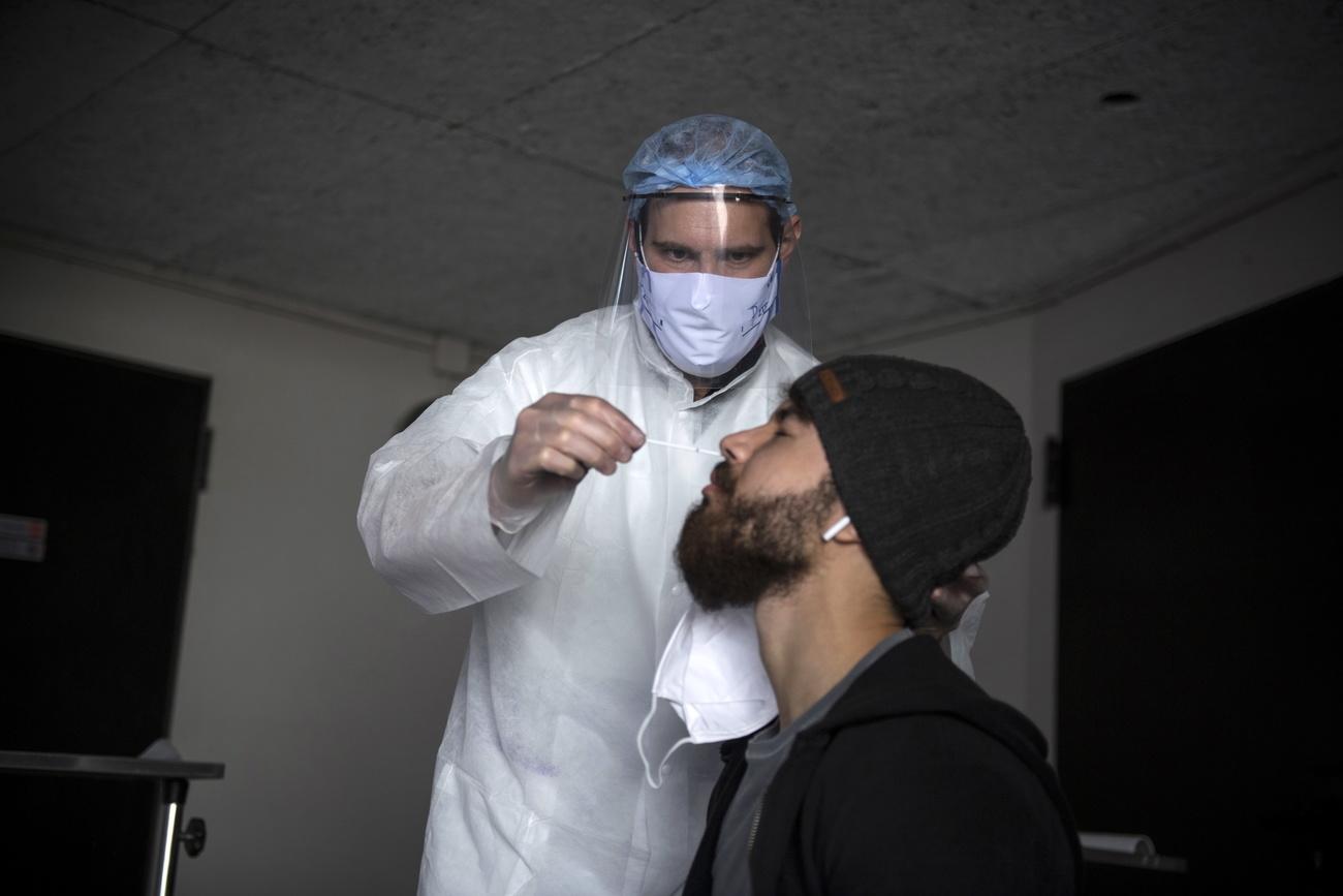 Un homme est testé pour détecter le SARS-CoV-2, le coronavirus développant la maladie Covid-19. Paris, le 7 mai 2020. [Keystone/epa - Julien de Rosa]