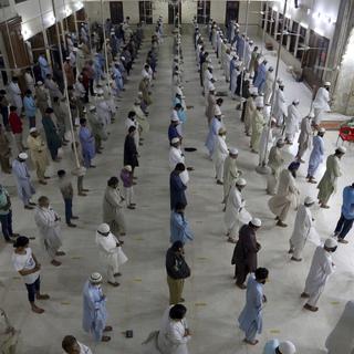 Dimanche 19 avril: les fidèles attendant la prière au Pakistan respectent les distances de sécurité. [Keystone - AP Photo/Fareed Khan]