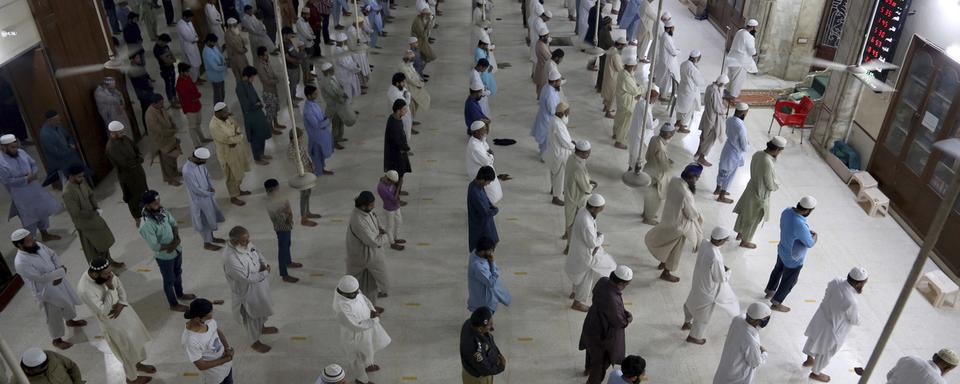 Dimanche 19 avril: les fidèles attendant la prière au Pakistan respectent les distances de sécurité. [Keystone - AP Photo/Fareed Khan]