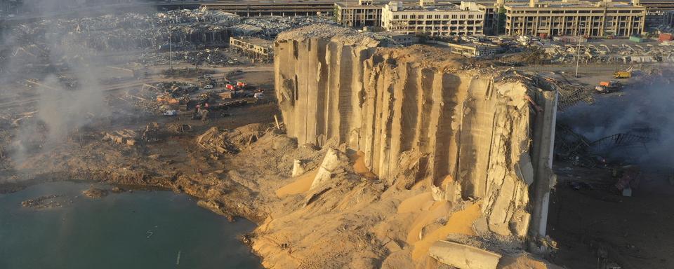 La double explosion a soufflé un silo et créé un àénorme cratère dans le poprt de Beyrouth. [AP/Keystone - Hussein Malla]