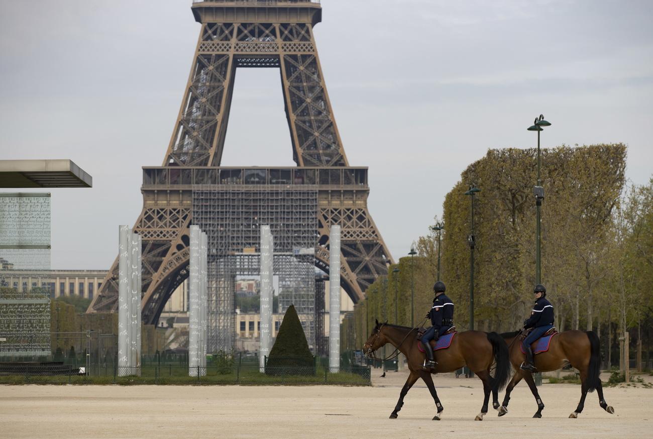 La police montée patrouille dans les environs de la Tour Eiffel à Paris, le 7 avril 2020. [Keystone/epa - Ian Langsdon]