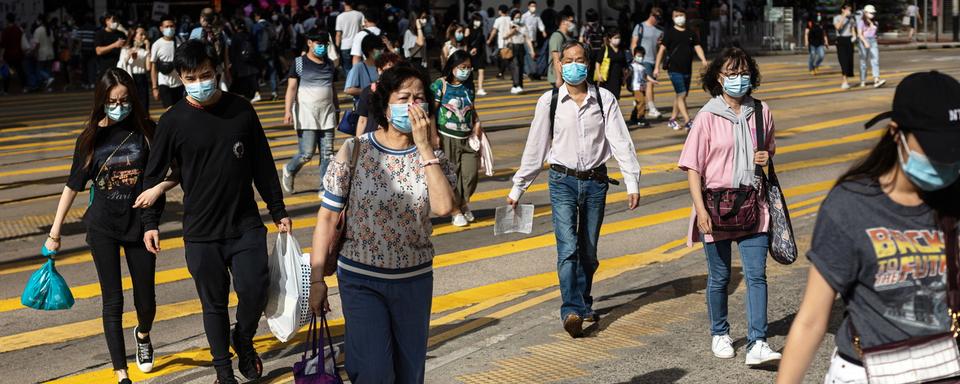 Piétons dans une rue de Hong Kong, 05.05.2020. [EPA/Keystone - Jérôme Favre]