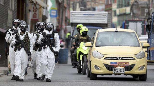 Soldats en patrouille pour faire respecter les restrictions dans une banlieue de Bogota, en Colombie. [AP/Keystone - Fernando Vergara]