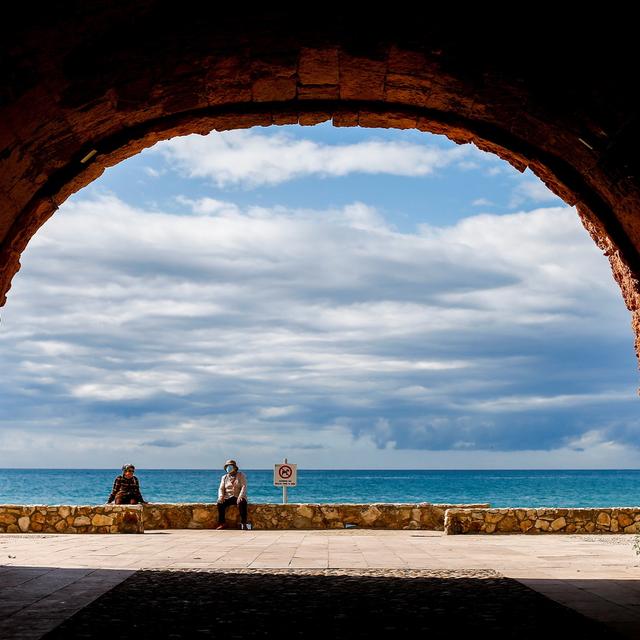 Deux personnes sont assises à distance près de la plage d'Altafulla, à Taragone en Espagne, le 13 mai 2020. [EPA/Keystone - Quique Garcia]