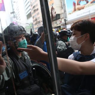 Un manifestant et un policier anti-émeute lors d'une manifestation pro-démocratie, le 24 mai 2020 à Hong Kong. [EPA/Keystone - Jérôme Favre]