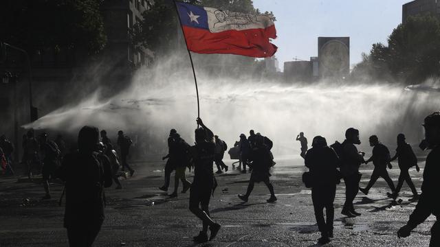 Des images de heurts au Chili vendredi 23 octobre. [Keystone - AP Photo/Esteban Felix]