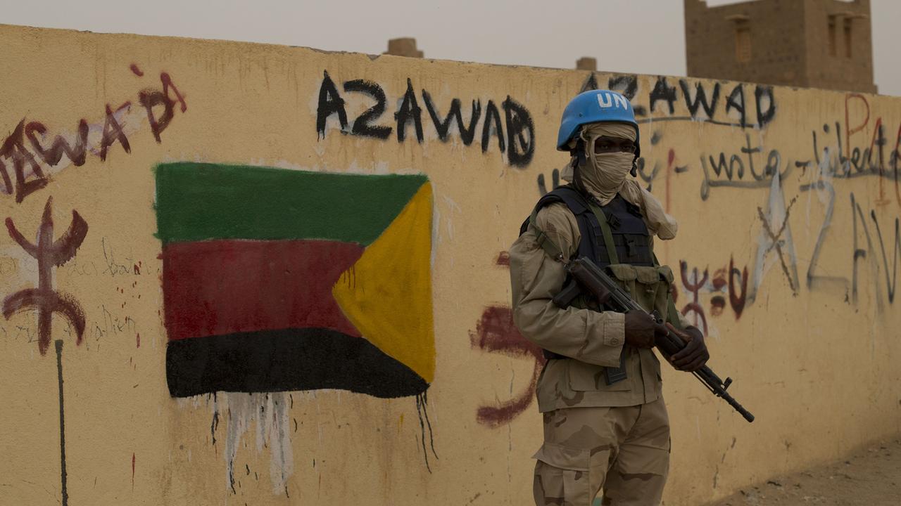 Un soldat de la mission de l'ONU au Mali à Kidal en 2013, devant une slogan de soutien à l'Azawad (CMA), alliance à dominante touareg d'anciens groupes armés rebelles. [AP Photo/Rebecca Blackwell]