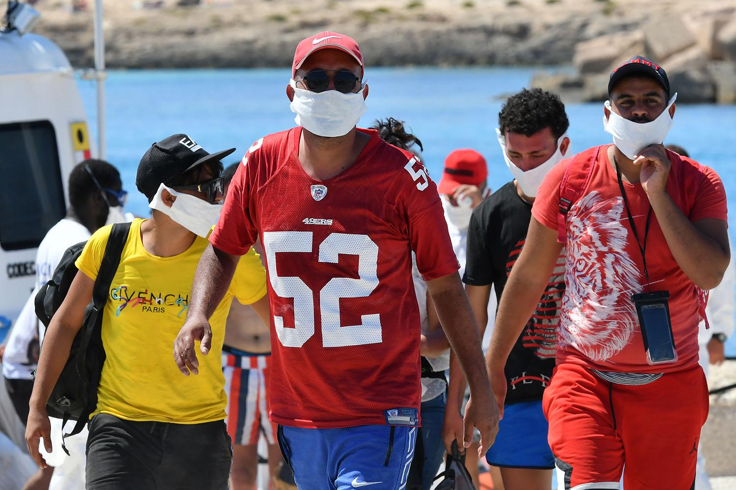 Des migrants tunisiens débarquent sur l'île italienne de Lampedusa, 30.07.2020. [AFP - Alberto Pizzoli]
