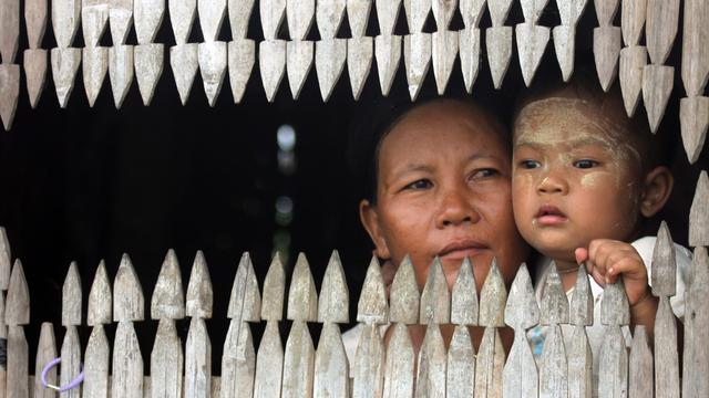 Une femme et son enfants à la fenêtre de leur maison à Nyaung Tone. Birmanie, mai 2011. [Keystone/AP photo - Khin Maung Win]