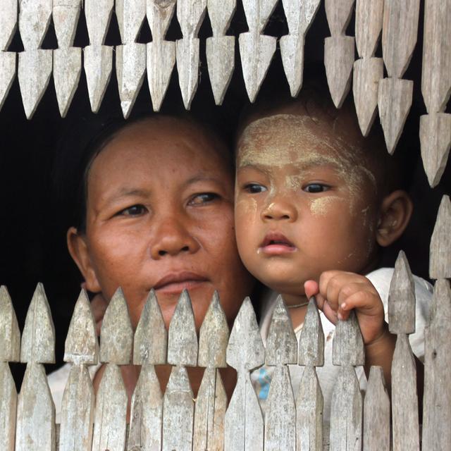 Une femme et son enfants à la fenêtre de leur maison à Nyaung Tone. Birmanie, mai 2011. [Keystone/AP photo - Khin Maung Win]