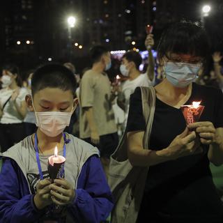 Des manifestants ont allumé des bougies en l'honneur des victimes du massacre de la place Tiananmen en 1989. Parc Victoria, Hong Kong, le 4 juin 2020. [Keystone/AP photo - Kin Cheung]
