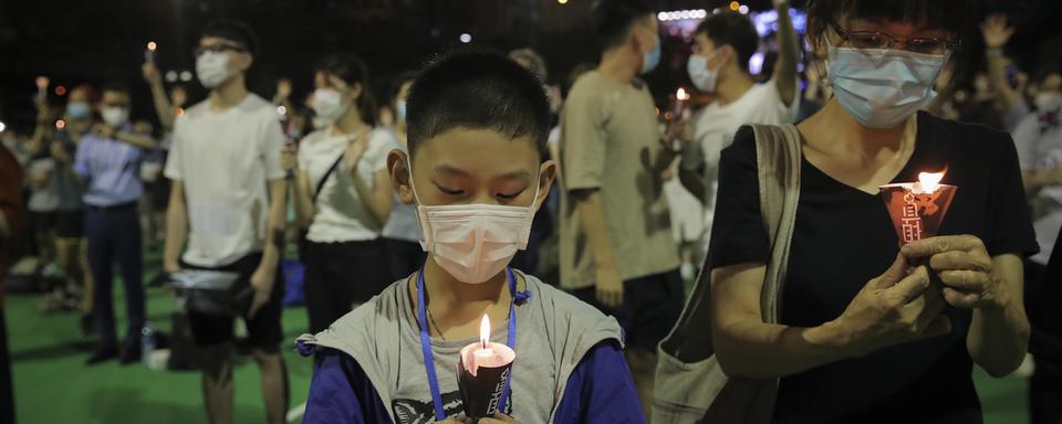 Des manifestants ont allumé des bougies en l'honneur des victimes du massacre de la place Tiananmen en 1989. Parc Victoria, Hong Kong, le 4 juin 2020. [Keystone/AP photo - Kin Cheung]